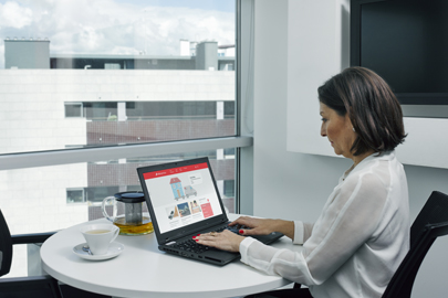 Senhora trabalha através de um portátil.